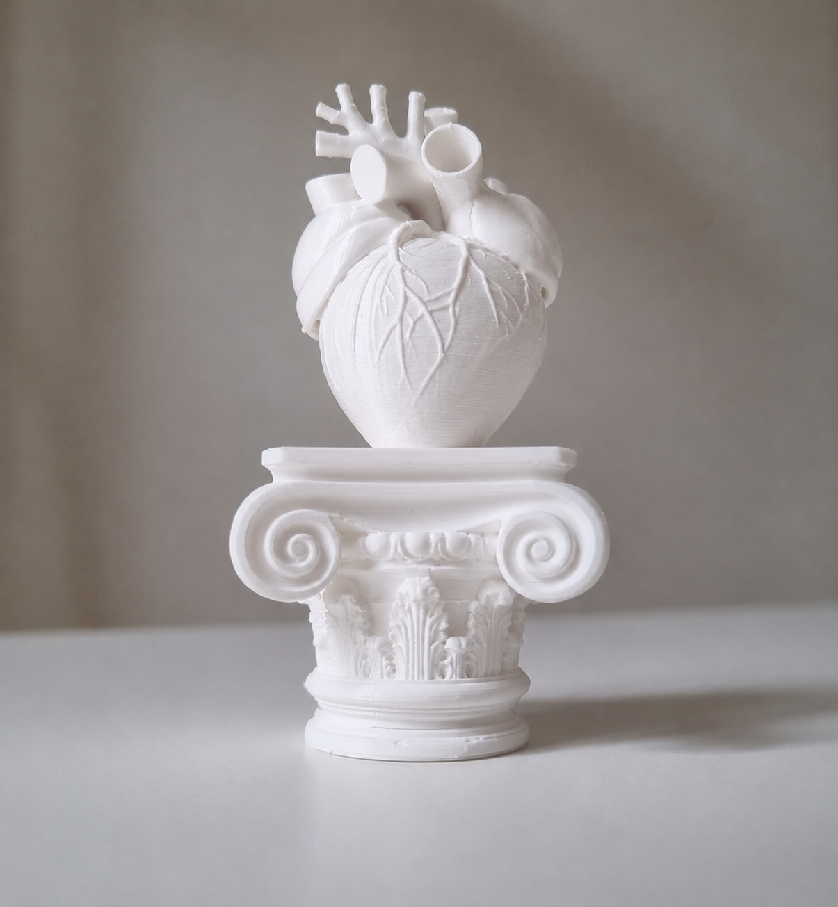 Cuore umano su capitello greco in stampa 3d bianco
