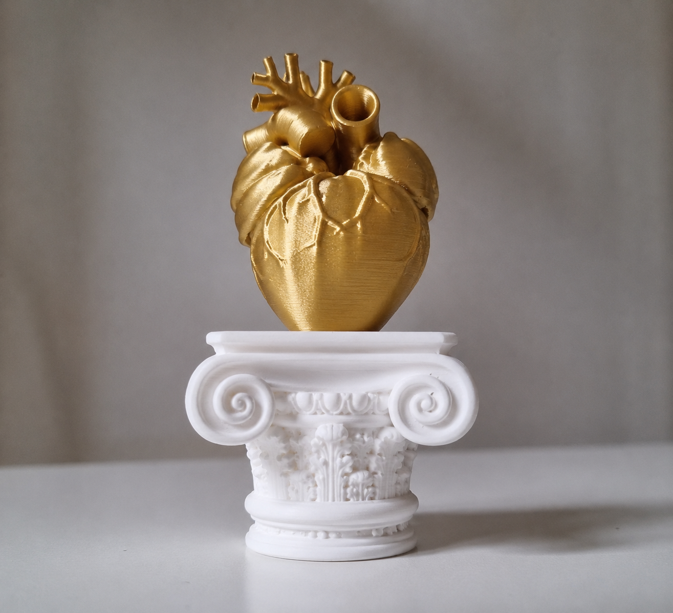 Cuore umano su capitello greco in stampa 3d gold