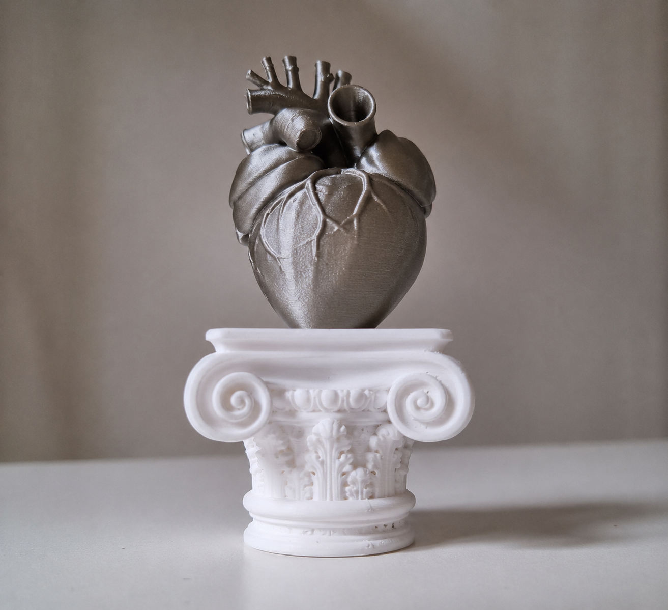 Cuore umano su capitello greco in stampa 3d iridio metal
