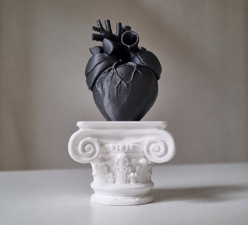 Cuore umano su capitello greco in stampa 3d nero metal