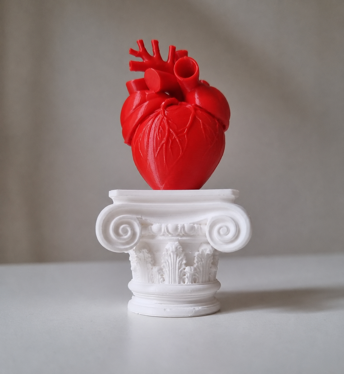 Cuore umano su capitello greco in stampa 3d rosso 