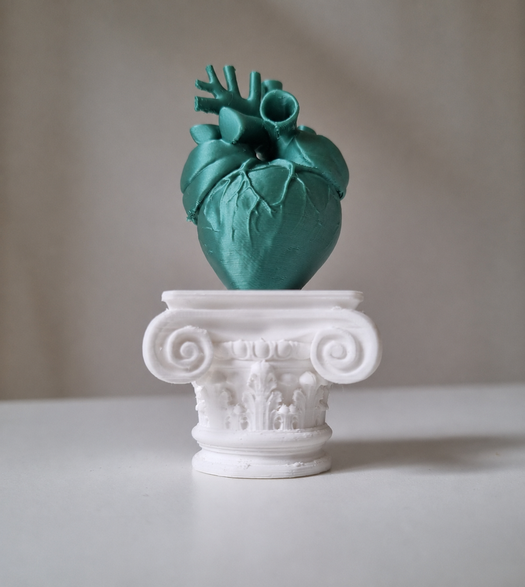 Cuore umano su capitello greco in stampa 3d verde metal